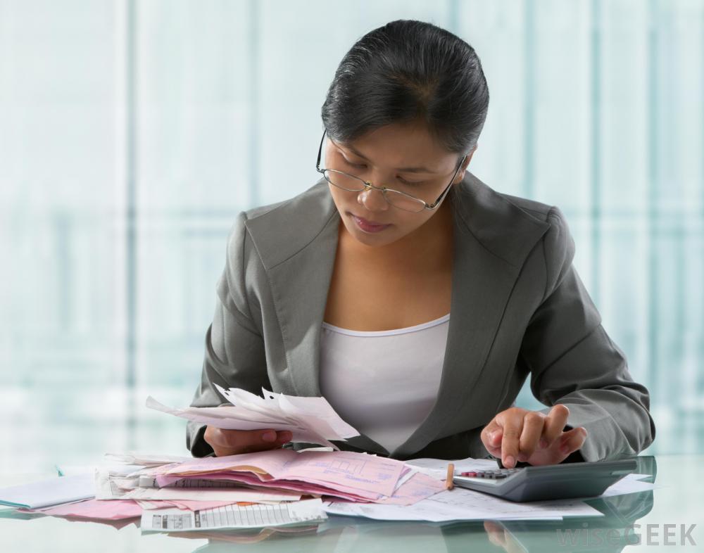 woman-using-calculator-while-reviewing-paperwork